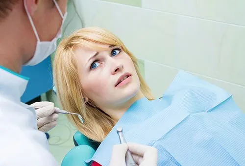 an anxious patient looks on in dread