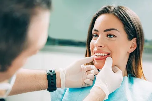 doctor checking woman's smile