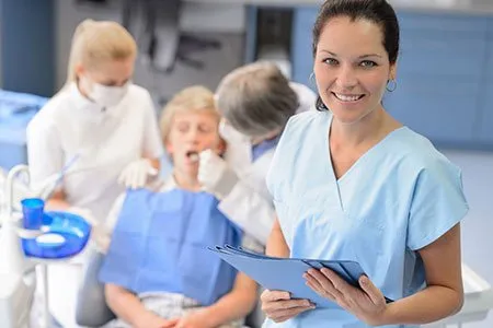 smailing staff with patient in backgroud