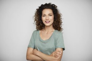 a smiling woman in a green shirt