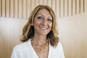 Smiling woman with gold necklace and white shirt