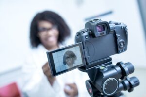 A woman presenting to a video camera