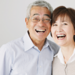 senior citizen couple smiling.