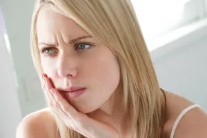 A woman experiencing wisdom teeth pain.