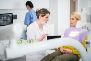 A dental assistant educating a patient during their dental visit